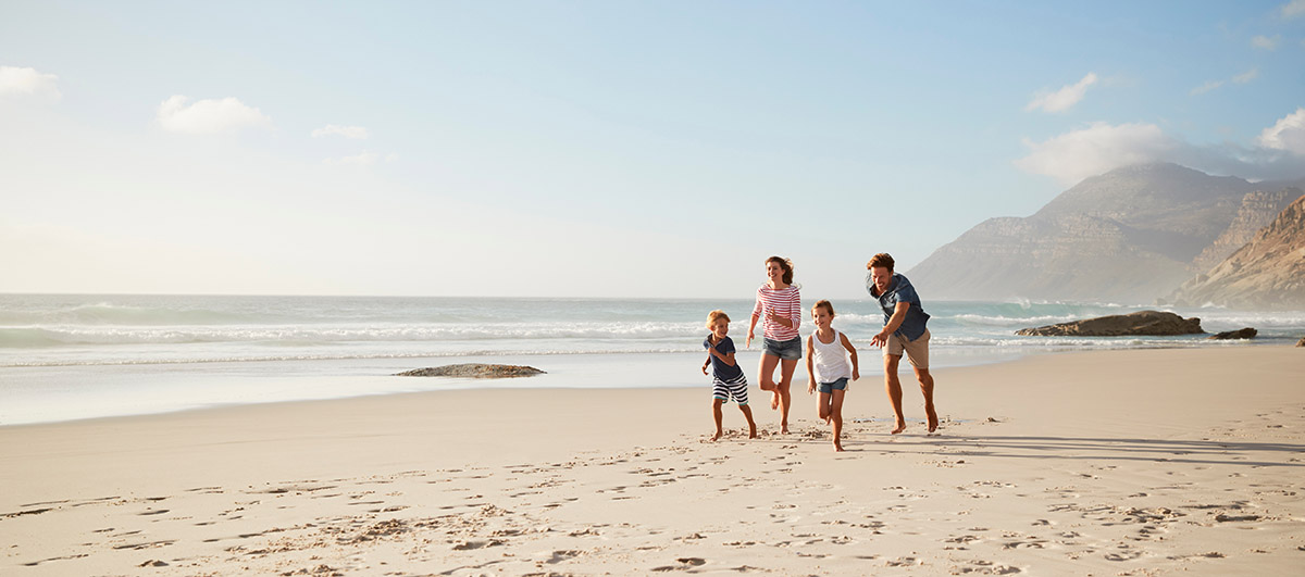Family running along a beach together knowing they're protected