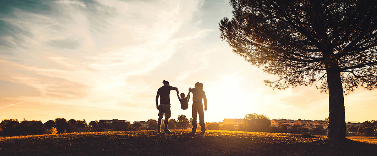 Silhouette of a happy family walking in the sunset, knowing they have the relevant protection in place